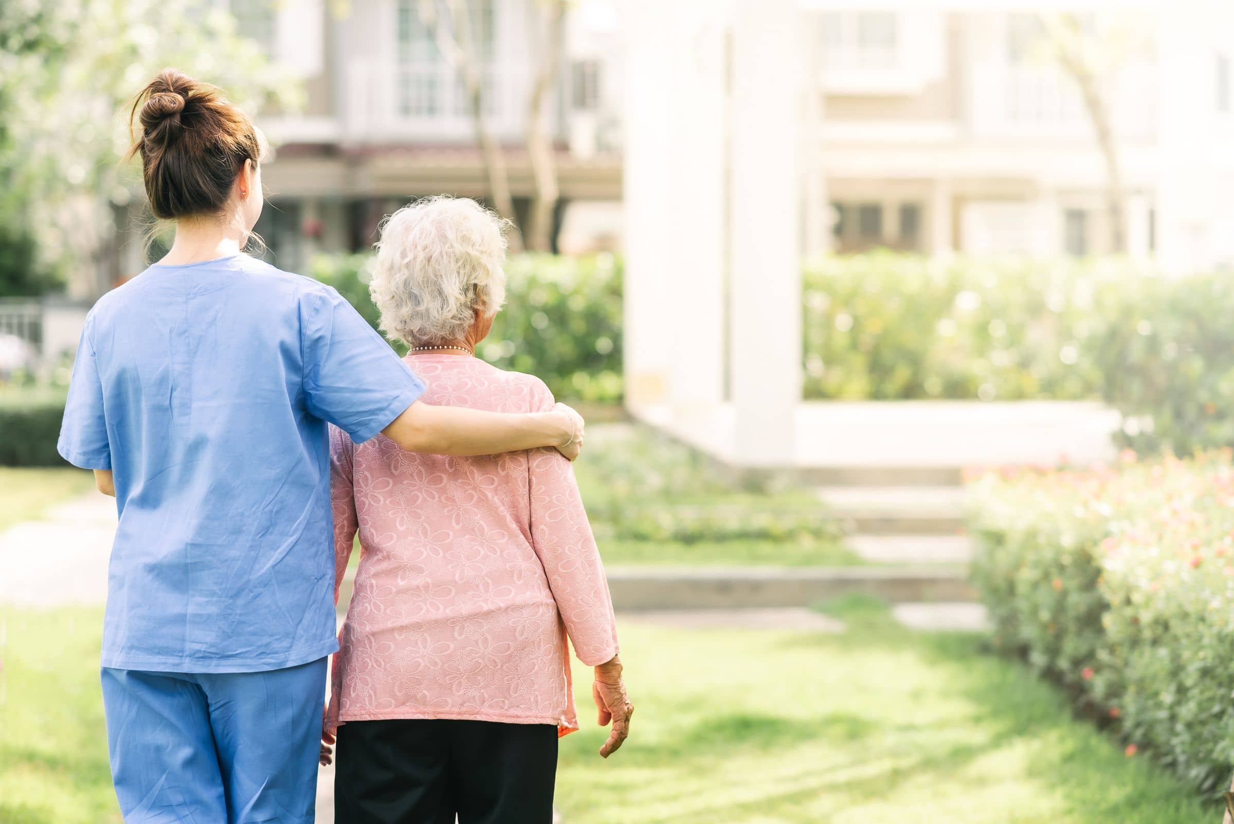 A caregiver walking outdoors with a client